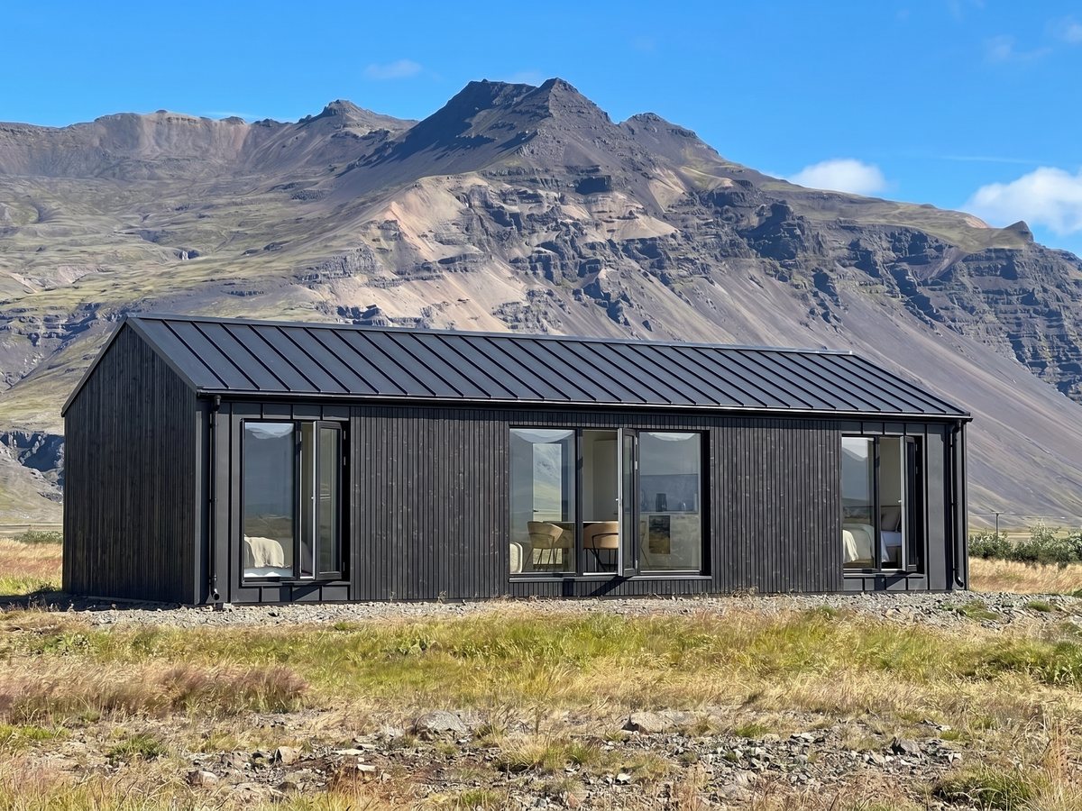 KUBO 56 svart heilsárshús í íslensku landslagi